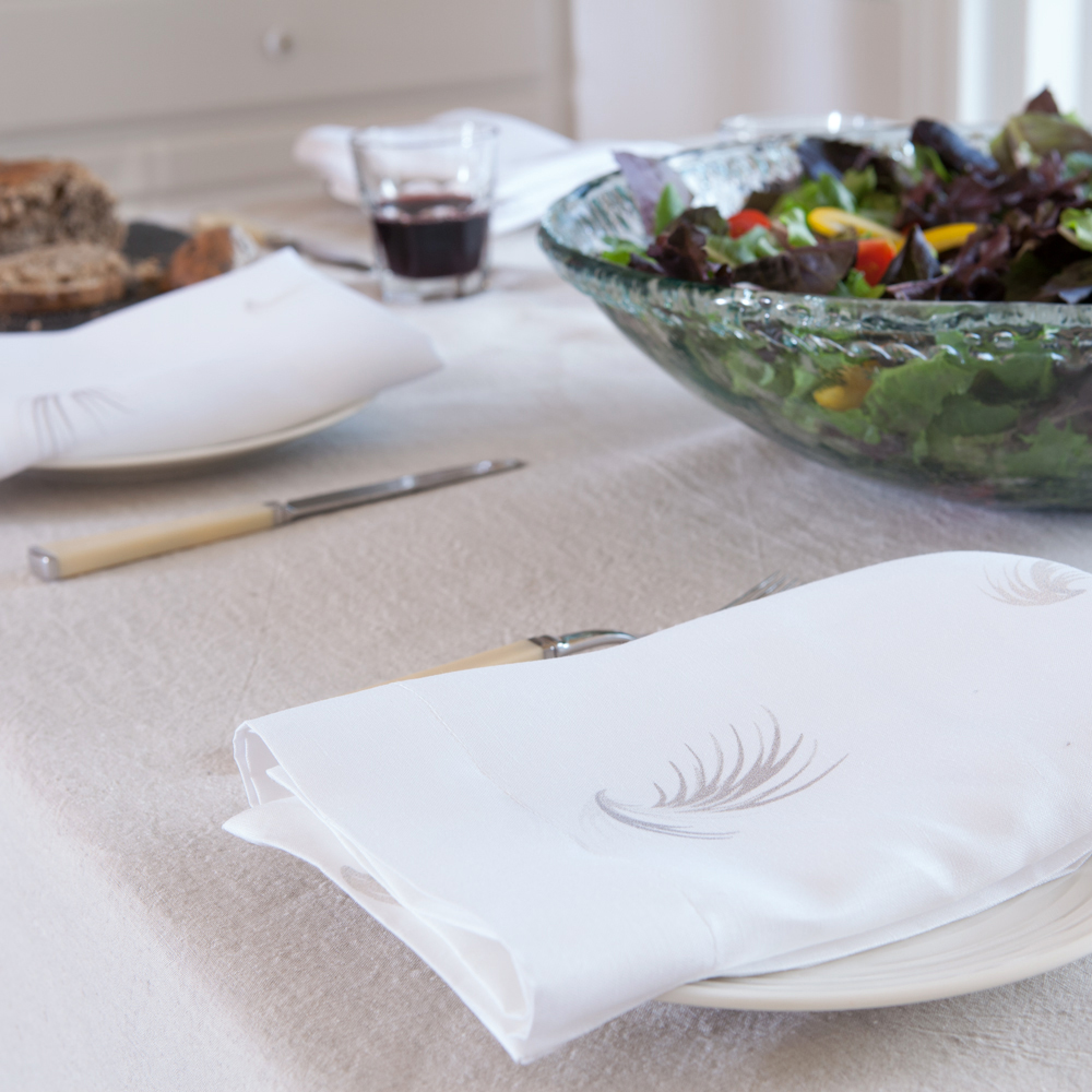 White linen napkin with feather print by Huddleson with natural table linens