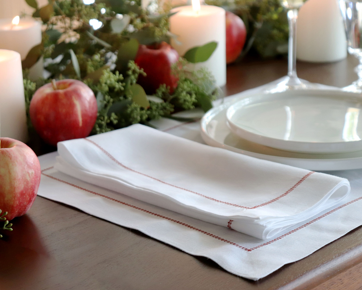 White linen napkin with red trim hemstitch Christmas placesetting 